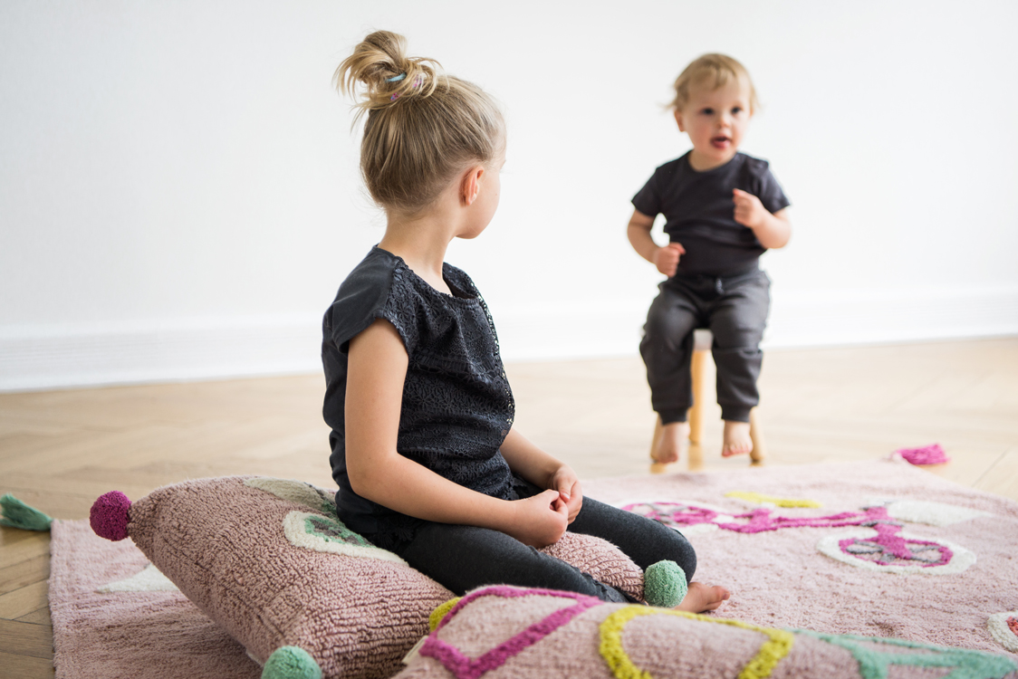 Kinder spielen mit Kissen und Teppichen in einer Altbauwohnung Interiorfotografie Hamburg