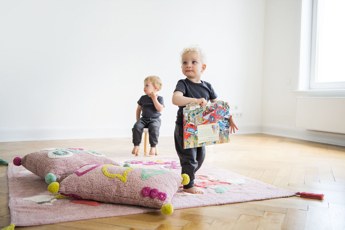 Kinder spielen mit Kissen und Teppichen in einer Altbauwohnung Interiorfotografie Hamburg