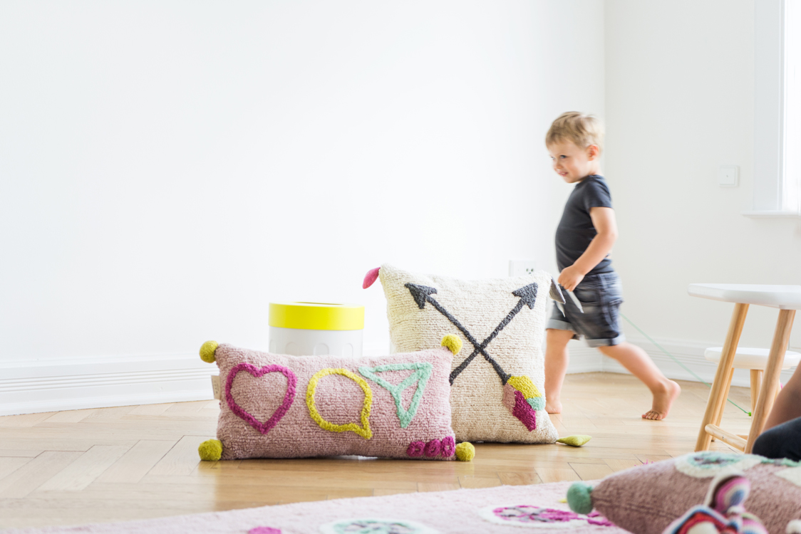 Kinder spielen mit Kissen und Teppichen in einer Altbauwohnung Interiorfotografie Hamburg