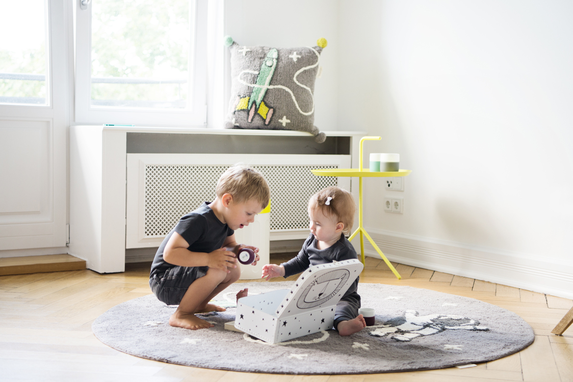 Kinder spielen mit Kissen und Teppichen in einer Altbauwohnung Interiorfotografie Hamburg