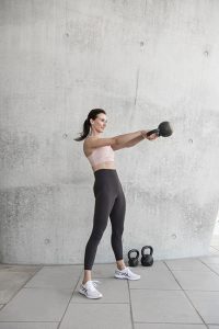Sport und Fitnessfotografie Lifestyle Portrait in Hamburg in der Hafen City Frau macht Fitnessübungen mit Kettleball