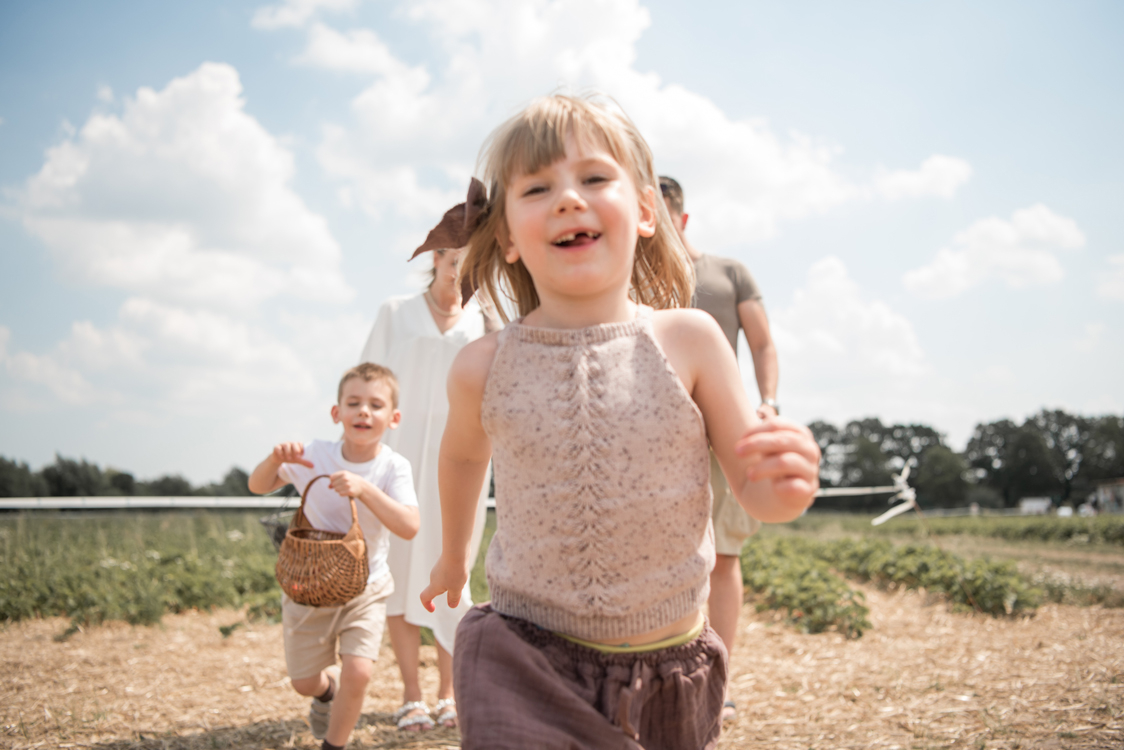 Kidsfotografie Lifestylefotografie in Hamburg für Social Media Familie pflückt Erdbeeren im Erdbeerfeld