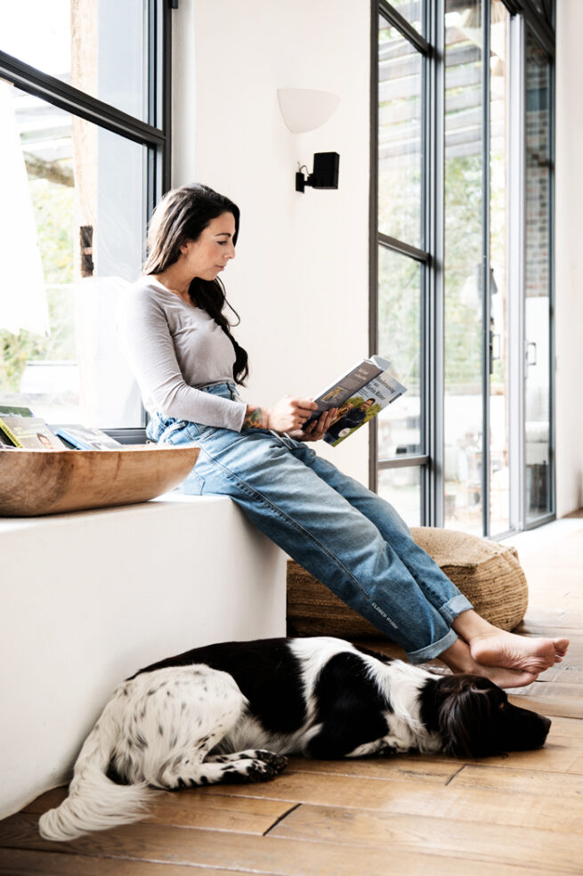 Frau sitzt auf einer Fensterbank und liest People und Lifestylefotografie in Hamburg on Location