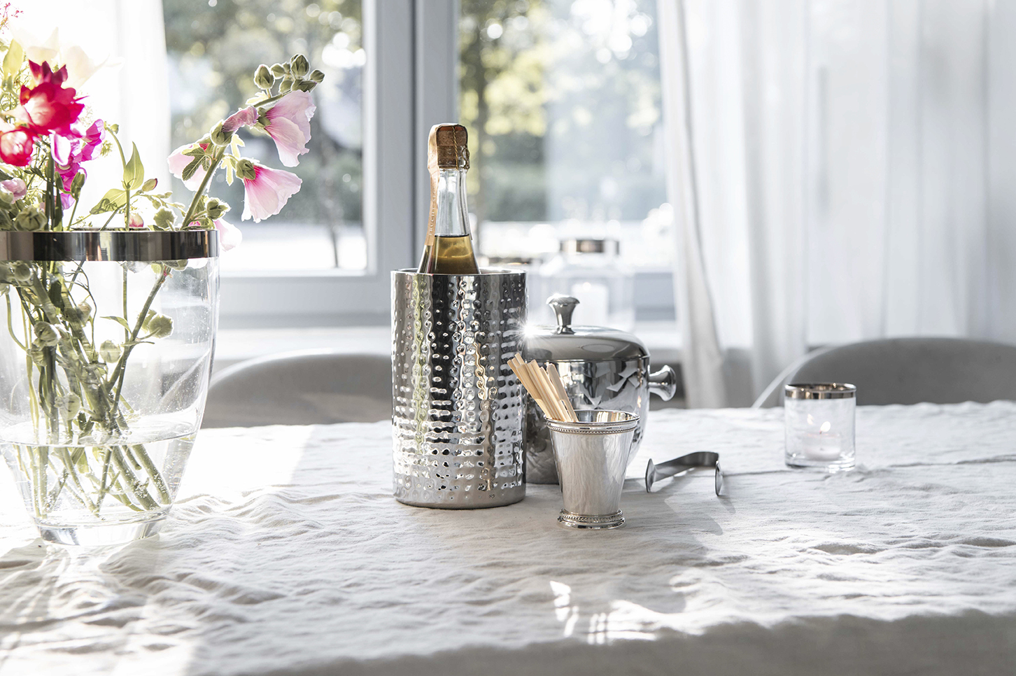 Interiorfotografie Stilllife in Hamburg, Sektkühler und Eiswürfelbehälter auf einem Tisch mit Leinendecke