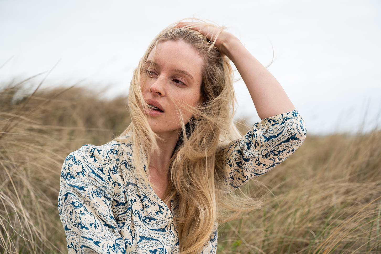 Lifestylefotografie am Strand mit blondem Model in Naturtönen