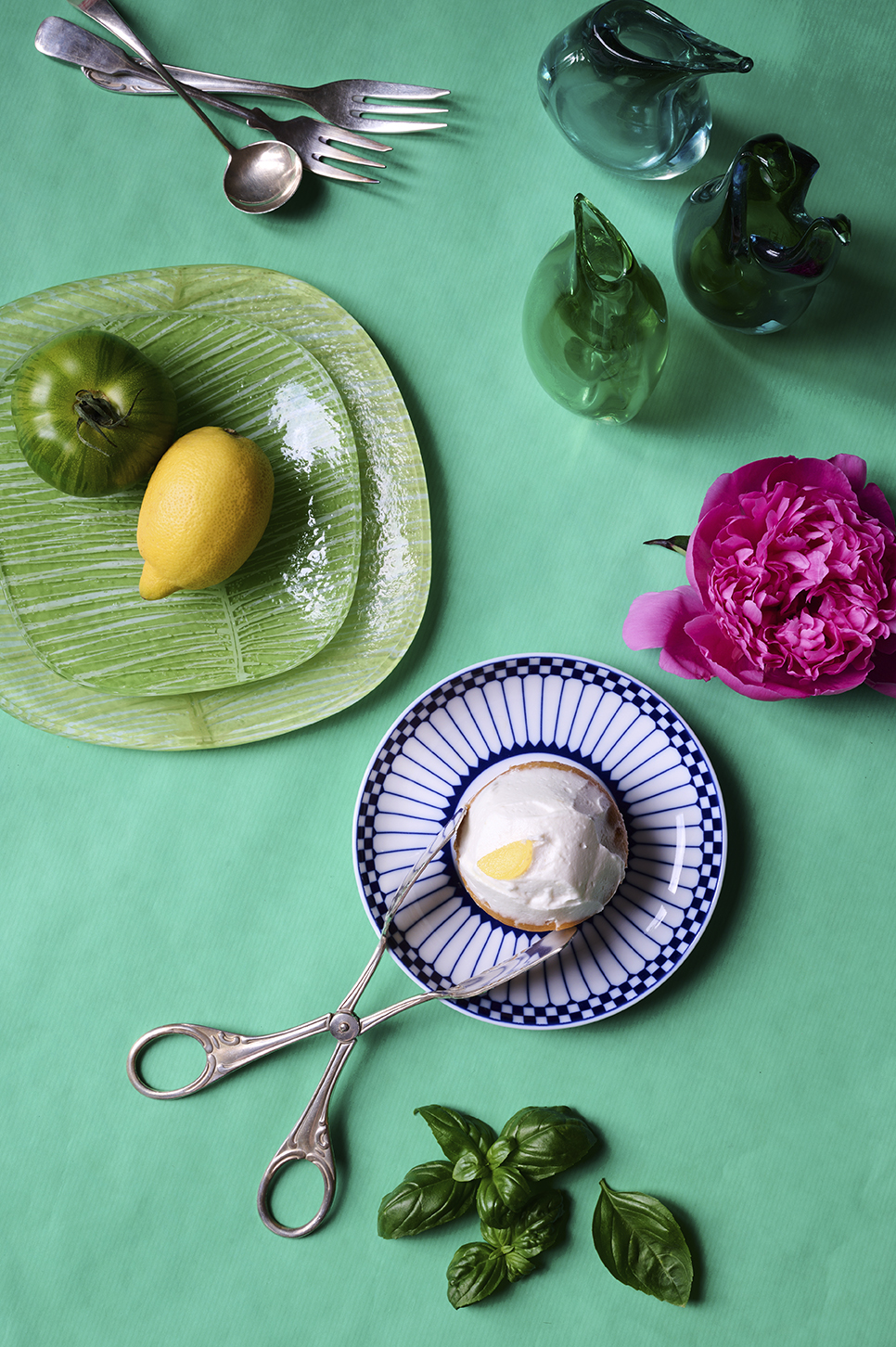 Colourful tableware still life with Murano glass, espresso cup and porcelain plate on a green table in a hospitality setting