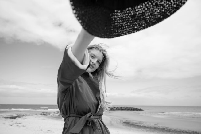 Lifestyle-Porträt einer Frau am Strand mit Hut – elegante, natürliche Fotografie mit Fokus auf Leichtigkeit und Authentizität Ostsee Nordsee