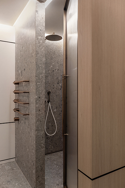 Moderne Dusche mit grauem Naturstein und Holzelementen in der HafenCity Hamburg