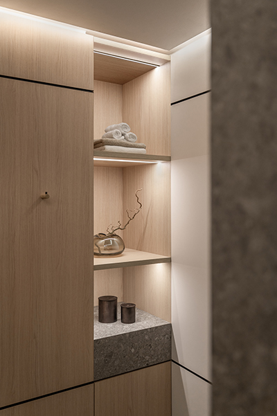 Moderner Flur mit Holzfronten, integrierter Beleuchtung und Natursteinwand in der HafenCity Hamburg