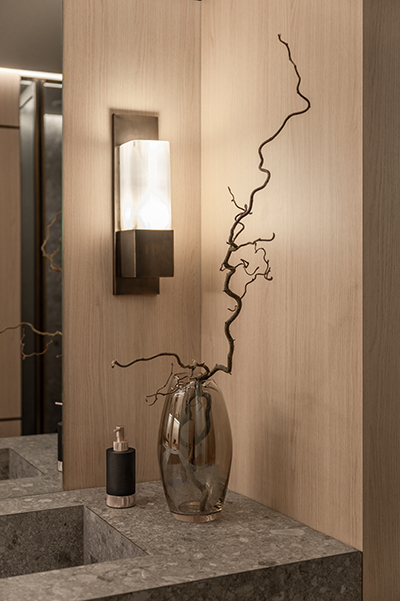 Wandleuchte auf heller Holzverkleidung mit feinem Astdekor in modernem Badezimmer in der HafenCity Hamburg