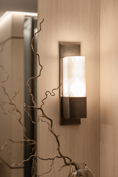 Wandleuchte auf heller Holzverkleidung mit feinem Astdekor in modernem Badezimmer in der HafenCity Hamburg