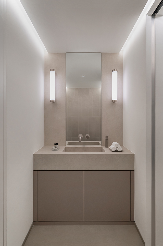 Minimalistisches Badezimmer mit hellem Waschtisch, symmetrischem Lichtdesign und klarer Formensprache in der HafenCity Hamburg