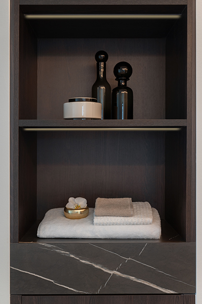 Badezimmerregal mit Handtüchern, Pflegeprodukten und dunkler Marmoroberfläche, Interiorfotografie in der Hamburger HafenCity.
