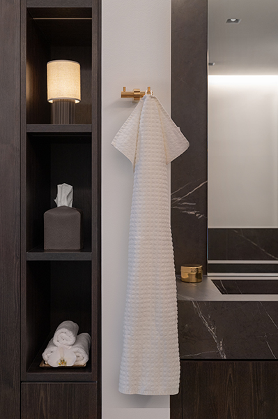 Modernes Badezimmerdetail mit dunklem Holz, Marmoroberfläche und goldenen Akzenten, Interiorfotografie in der Hamburger HafenCity.