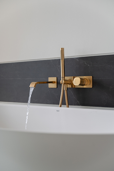 Goldene Armatur über einer weißen Badewanne, Interiorfotografie eines modernen Badezimmers in der Hamburger HafenCity.