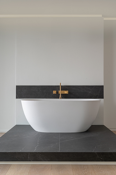 Freistehende Badewanne mit goldener Armatur in modernem Badezimmer, Interiorfotografie in der Hamburger HafenCity.