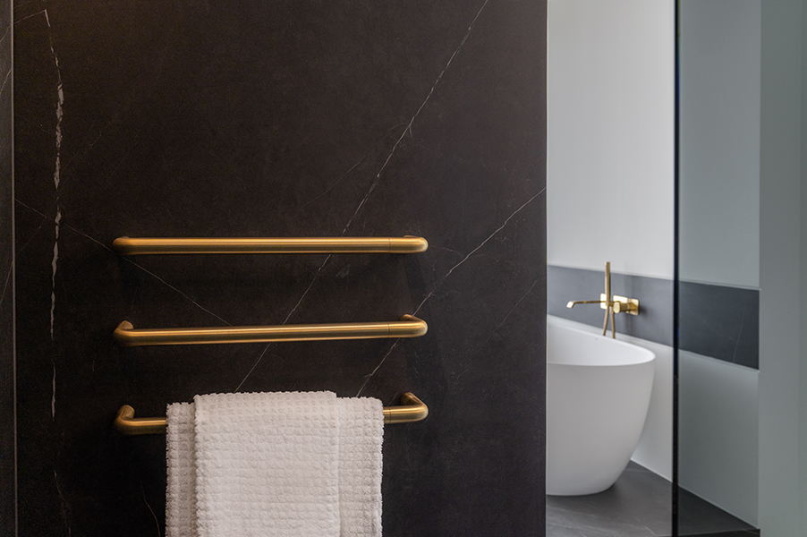Goldene Armatur über einer weißen Badewanne, Interiorfotografie eines modernen Badezimmers in der Hamburger HafenCity.