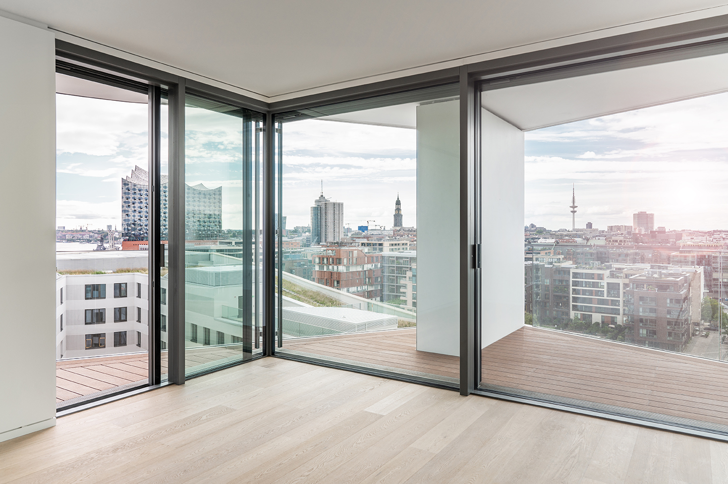 Helles Wohnzimmer mit bodentiefen Fenstern und Blick über den Hamburger Hafen, Interiorfotografie im Sandtorhafen.
