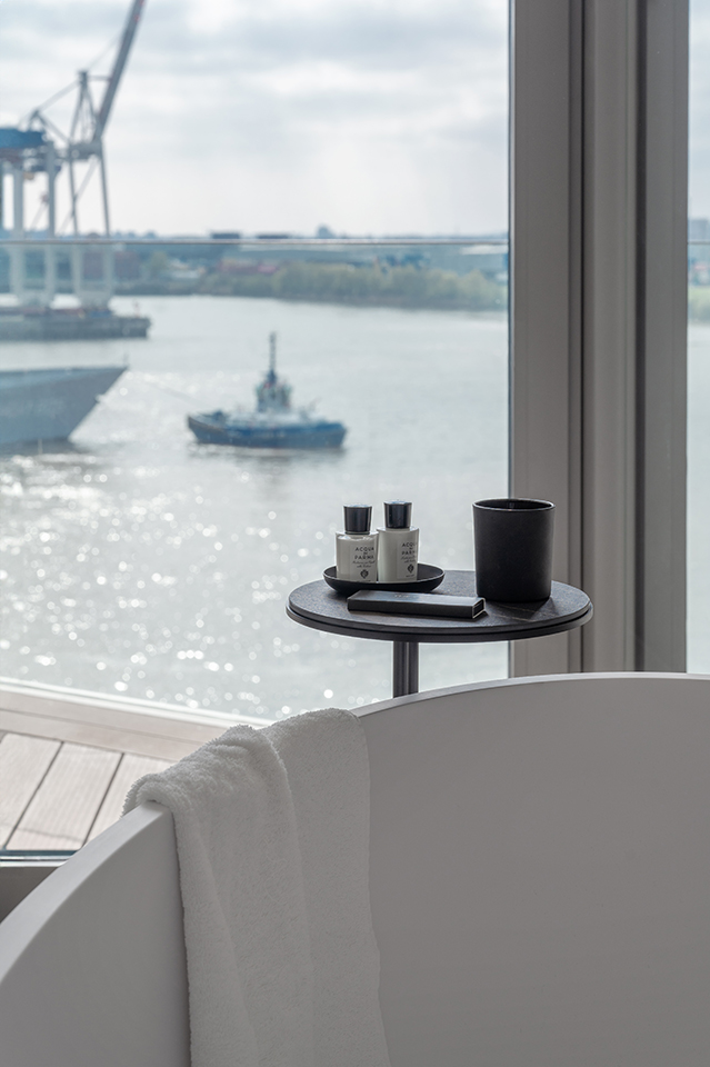 Badewanne mit Tablett und Handtuch vor Panoramafenster mit Hafenblick, Interiorfotografie in der Hamburger HafenCity.