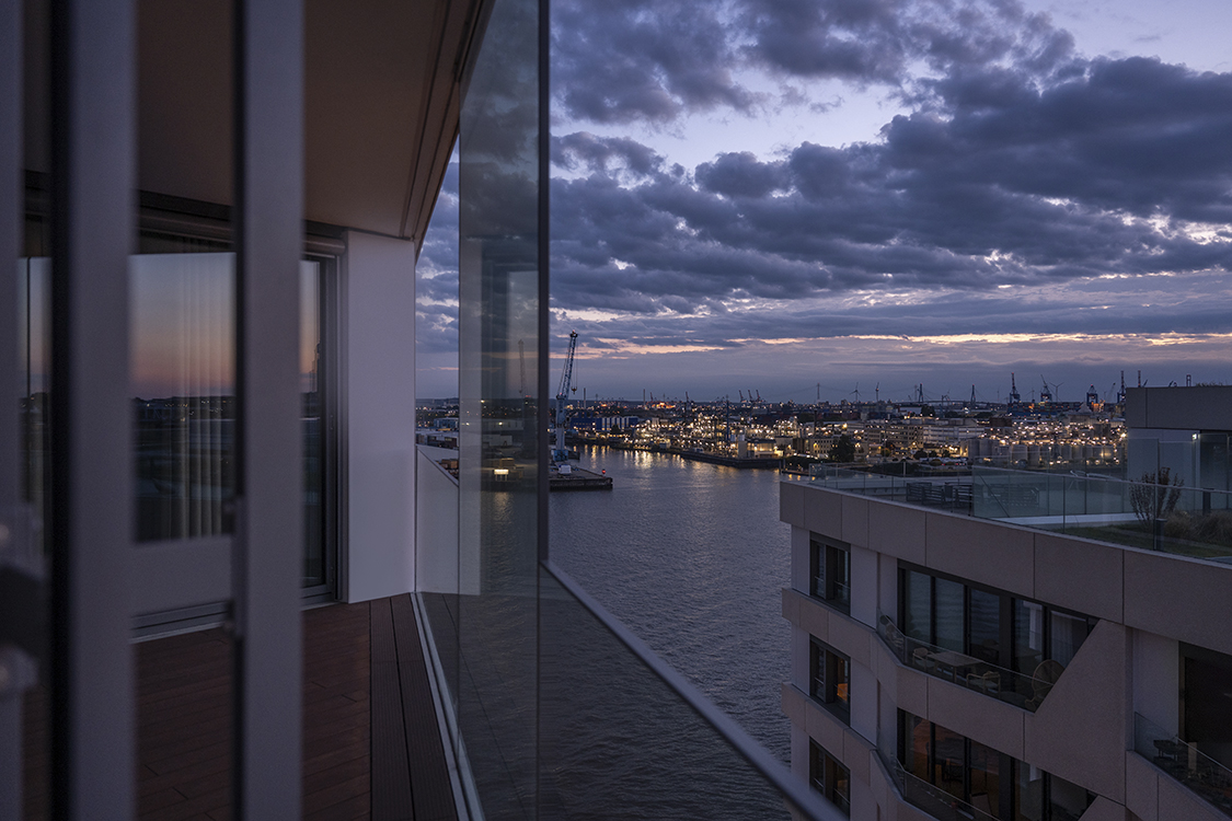 Balkon Hamburg mit Blick auf Wasser und Stadt bei blauer Stunde