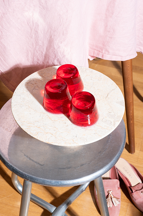 Rote Gläser auf kleinem Tisch, reduziertes Tableware Stilllife im Lifestyle Kontext