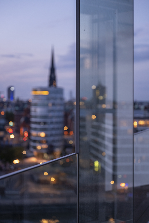 Moderne Stadtarchitektur mit Glasfassade und Stadtlichtern in der Dämmerung