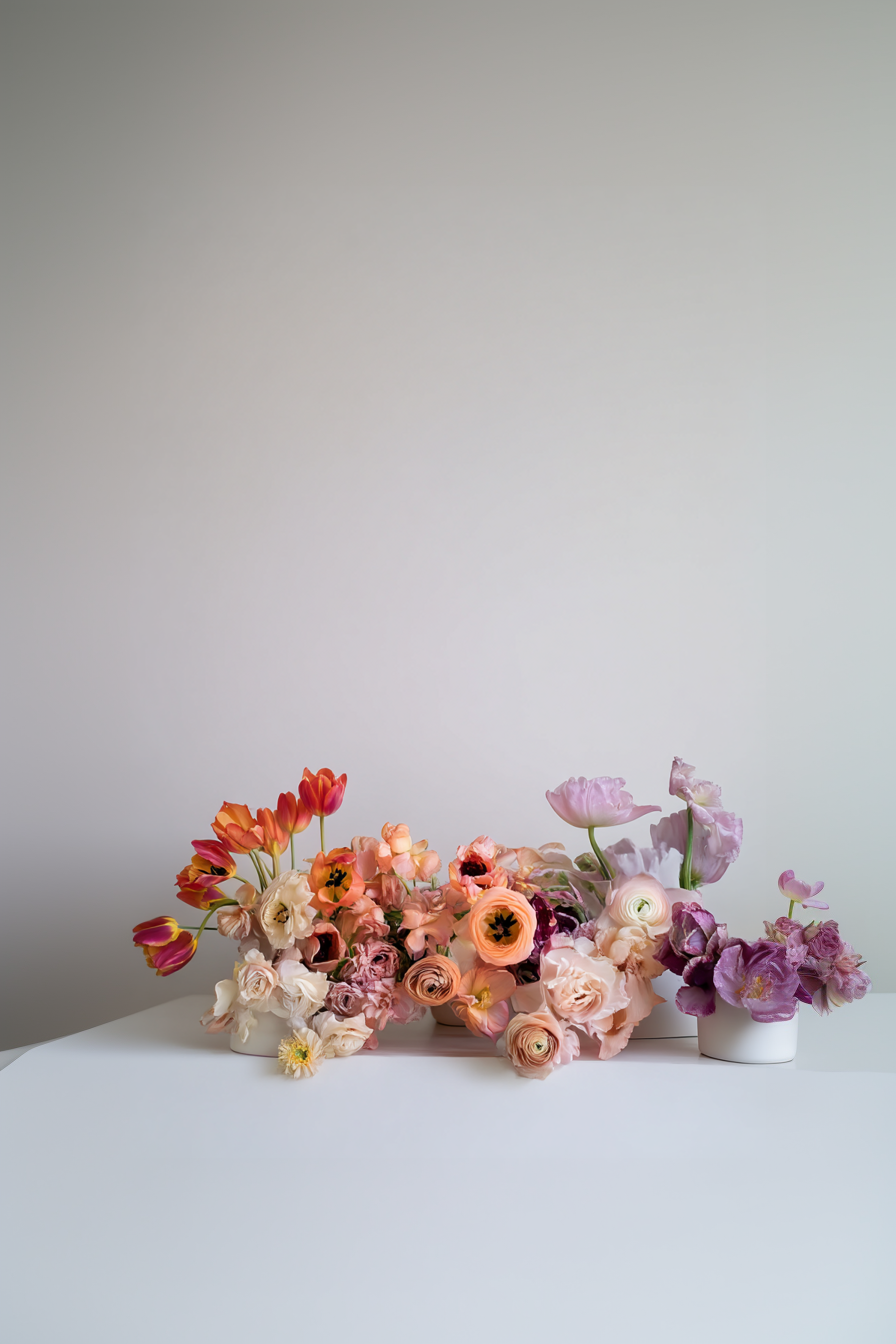 Editorial Stillleben mit pastellfarbenen Blumen auf minimalistischem Studio-Set