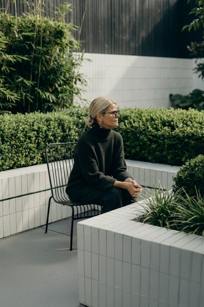 AI gestützte Outdoor Szene mit Frau auf Bank im Garten im natürlichen Tageslicht umgeben von Pflanzen