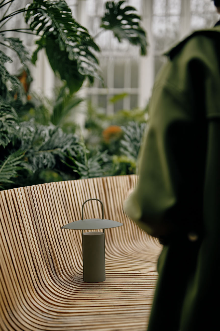 AI gestützte Szene mit Designleuchte auf strukturierter Sitzfläche im Garten im natürlichen Tageslicht