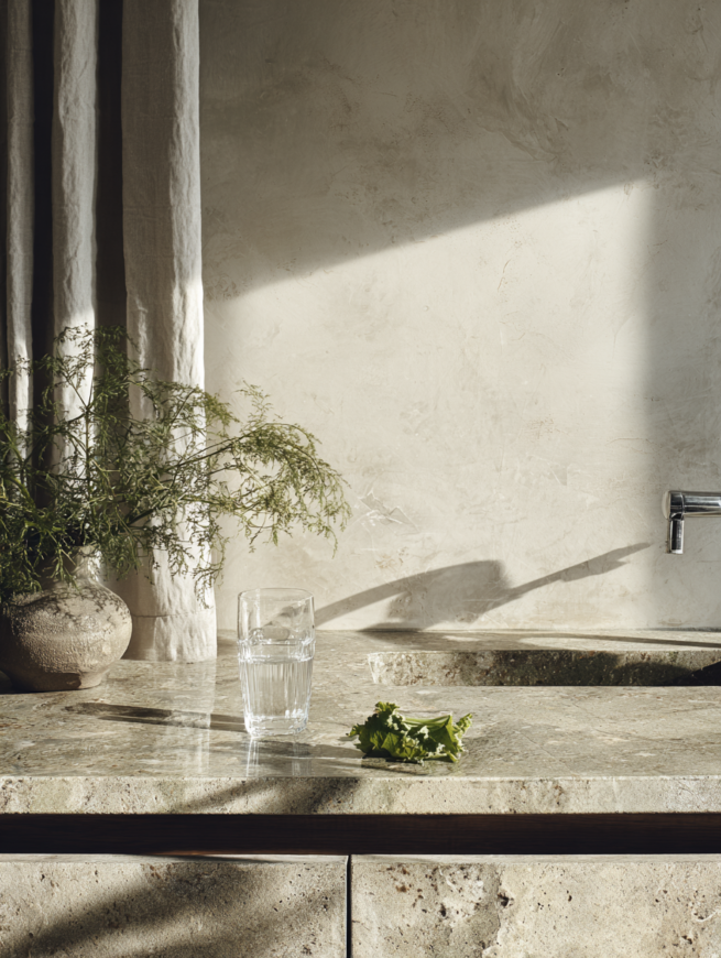 Küchenspüle mit Kräutern und Glas im natürlichen Tageslicht in minimalistischer Interior Szene AI