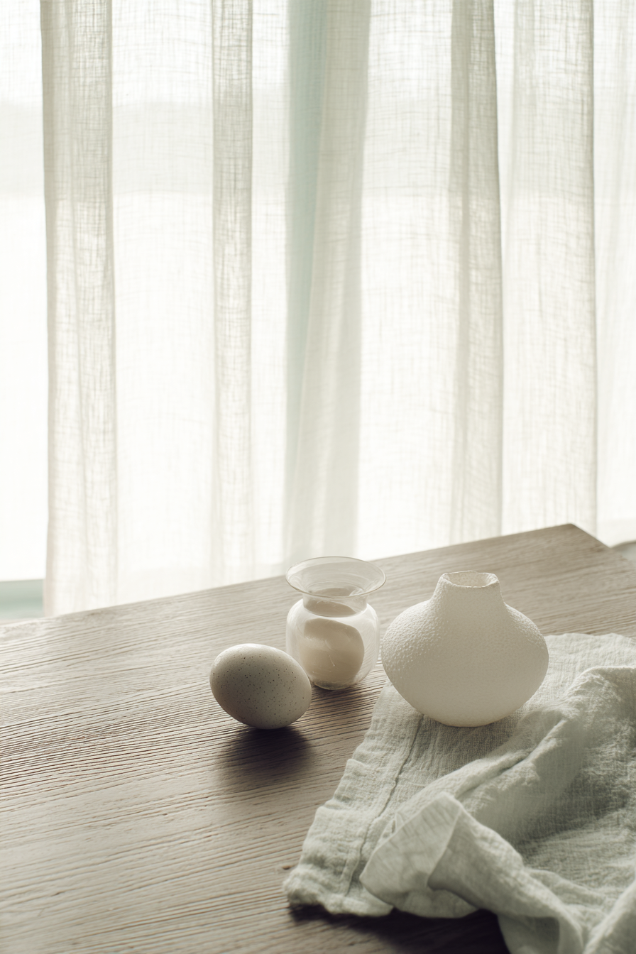 Minimalistisches Interior mit Keramikobjekten auf Holztisch im weichen Tageslicht AI generiert